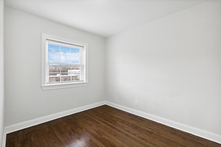 an empty room with wood floors and a window