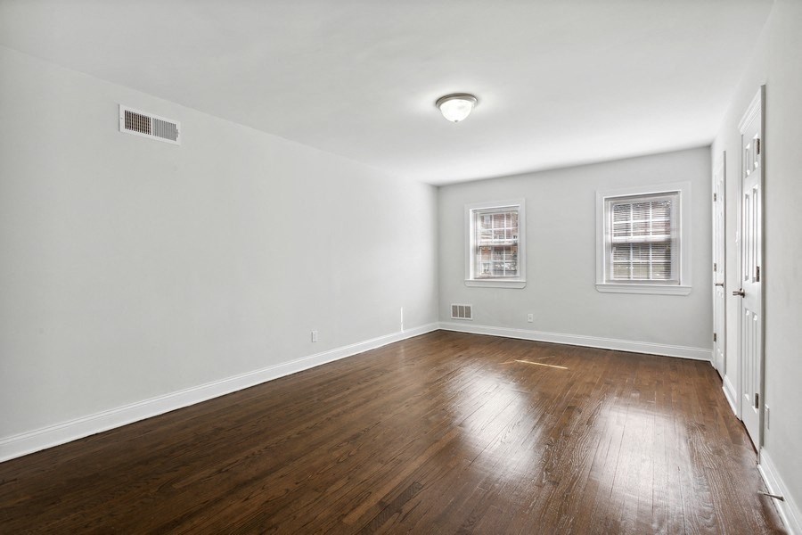 an empty living room with wood floors and white walls
