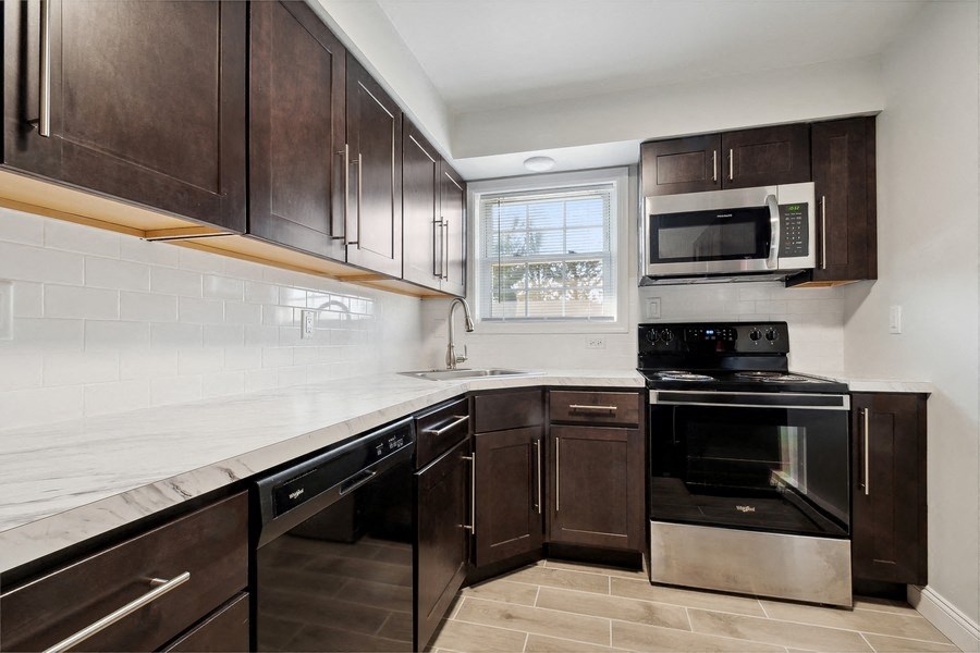 a kitchen with wooden cabinets and a stove and a microwave