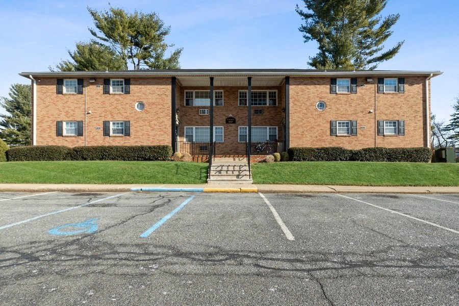 a large brick apartment building in a parking lot