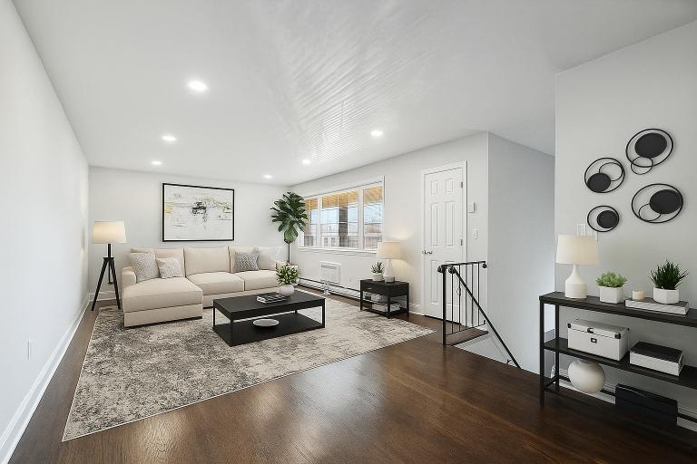 A modern living room with a white couch, a coffee table, and a rug.