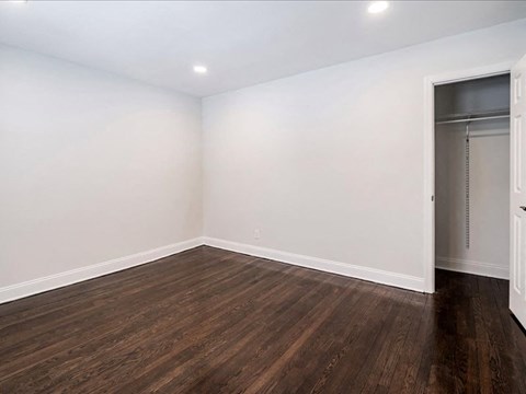 A room with wooden flooring and a white door.