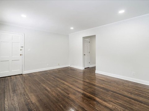 A room with wooden floors and two white doors.