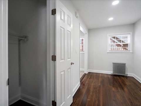 A room with a white door and a window with a view of a building outside.