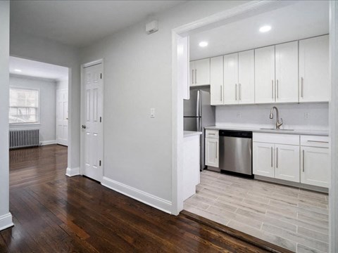 A kitchen with white cabinets and a stainless steel dishwasher.