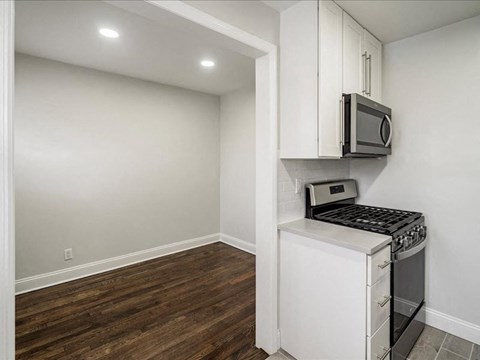 A kitchen with a microwave and oven built into the cabinetry.