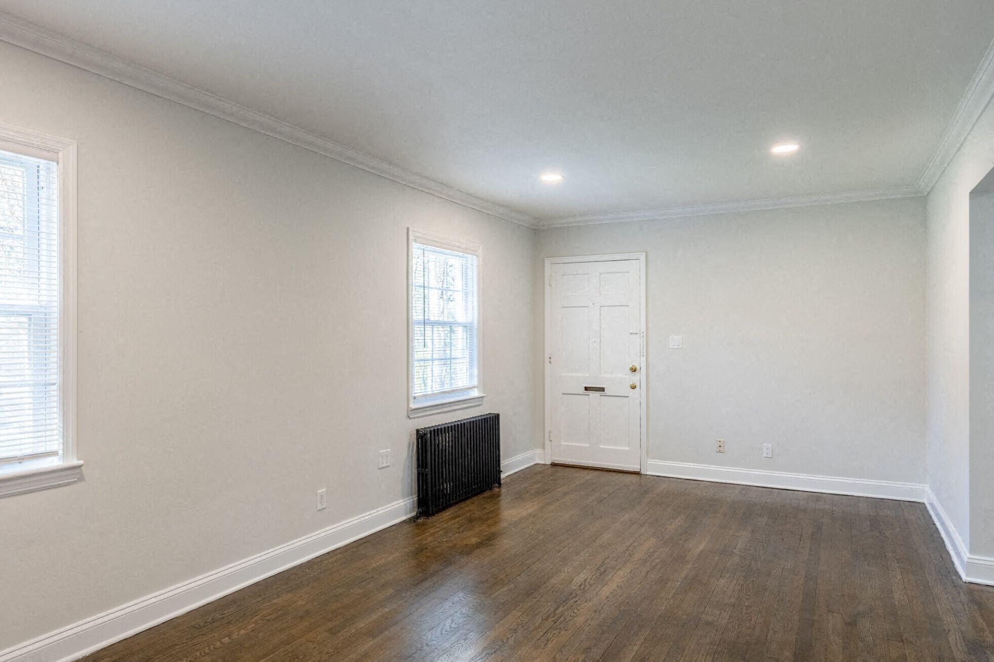 an empty living room with white walls and a white door