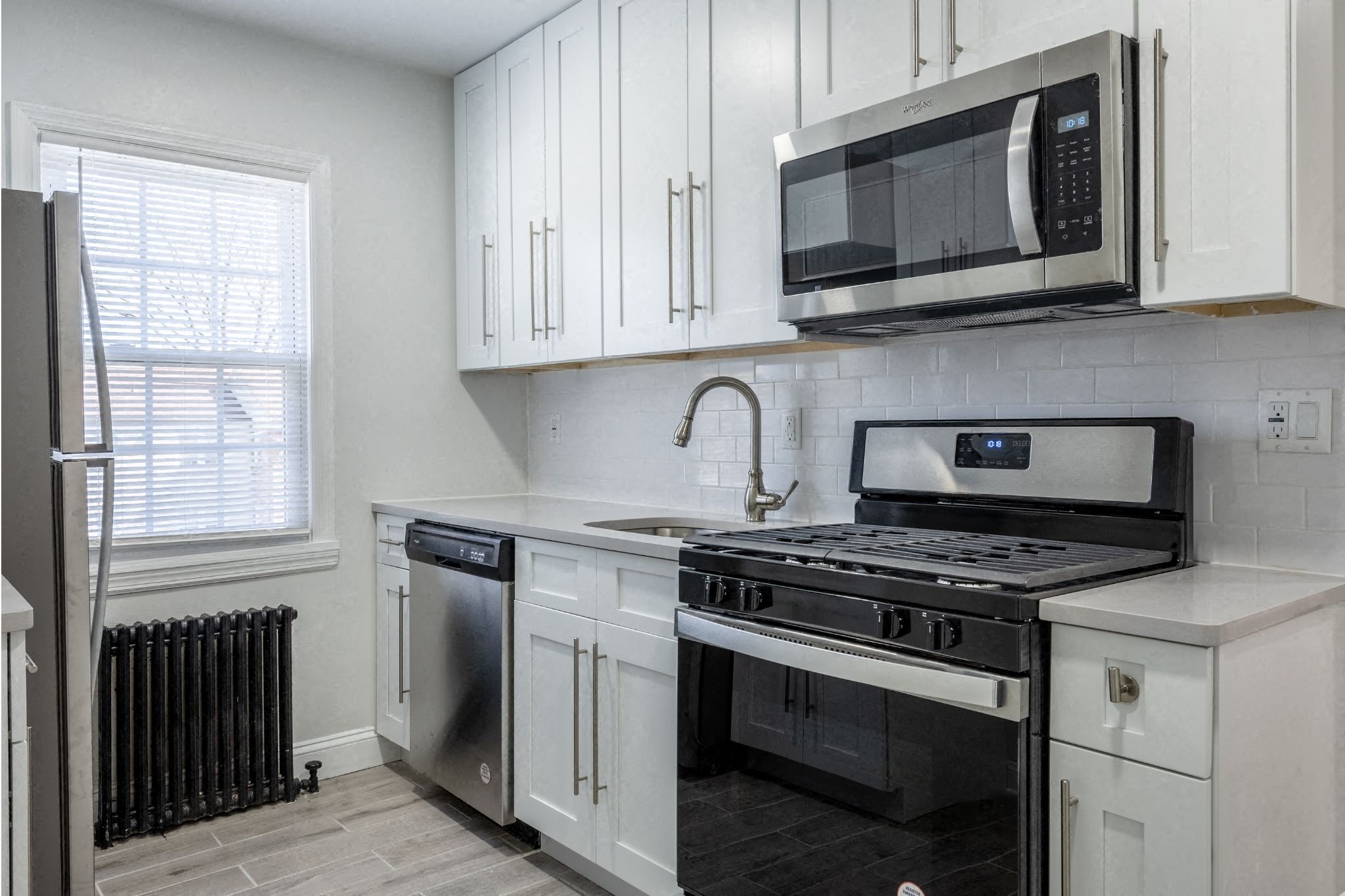 a kitchen with white cabinets and a stove and a microwave