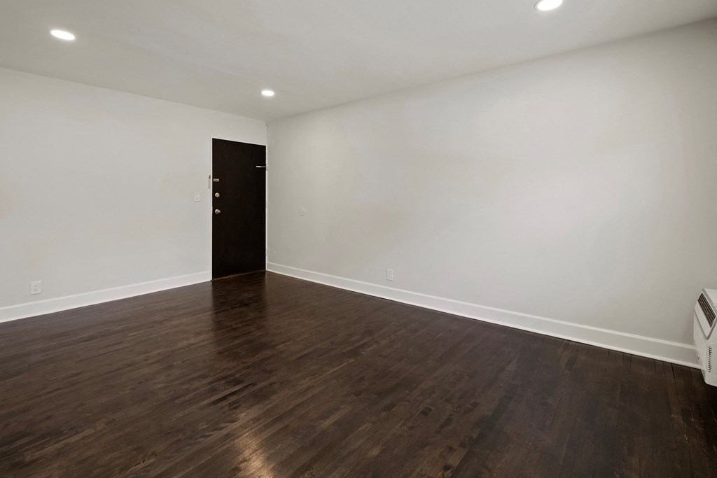 a empty living room with white walls and wood floors