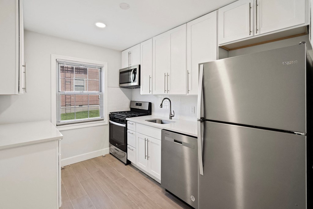 a kitchen with stainless steel appliances and white cabinets