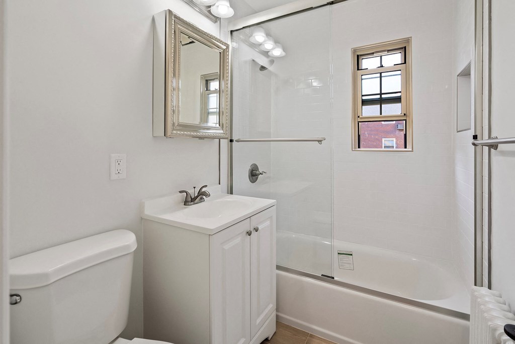 a white bathroom with a shower and a sink and a toilet