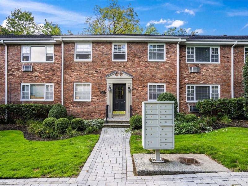 a brick house with a sidewalk in front of it