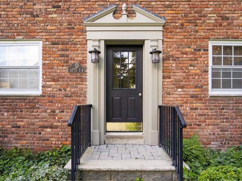 the front of a brick house with a black door