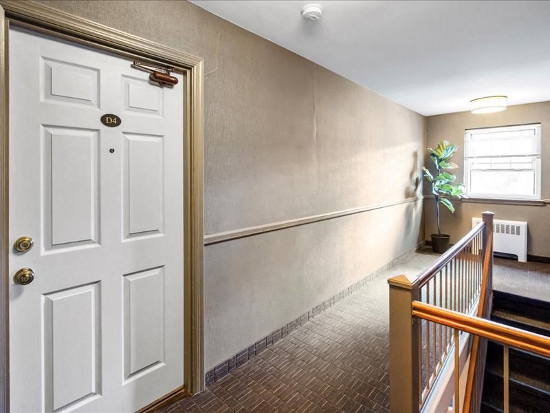 a hallway with a white door and a staircase