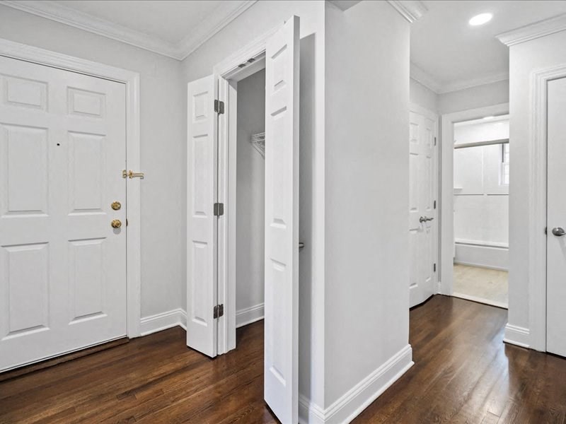 a bedroom with white doors and a wood floor