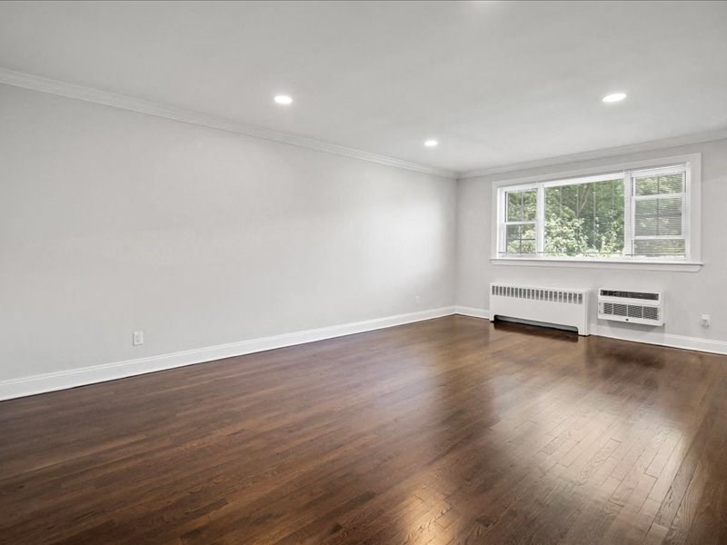 a living room with a hard wood floor and a window