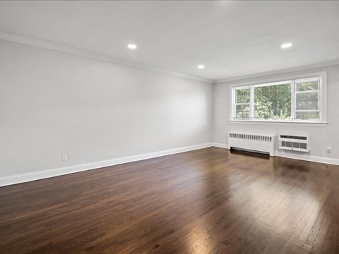 a living room with a hard wood floor and a window