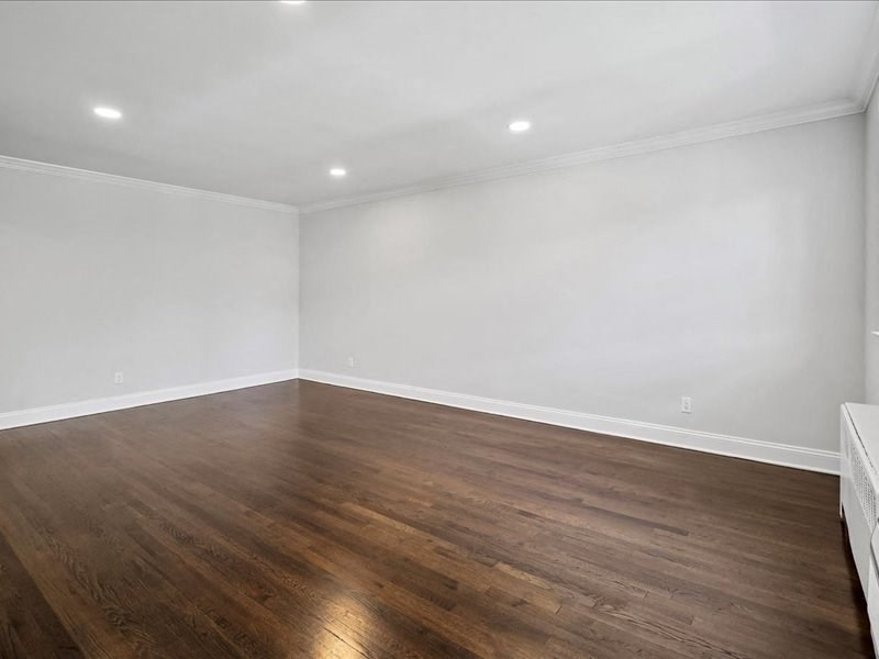 an empty living room with white walls and wood floors