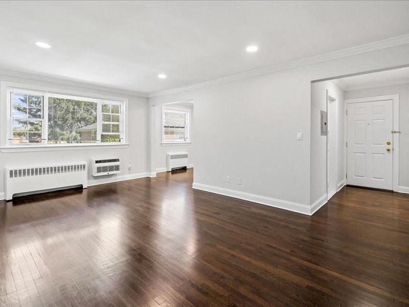a living room with white walls and wood floors