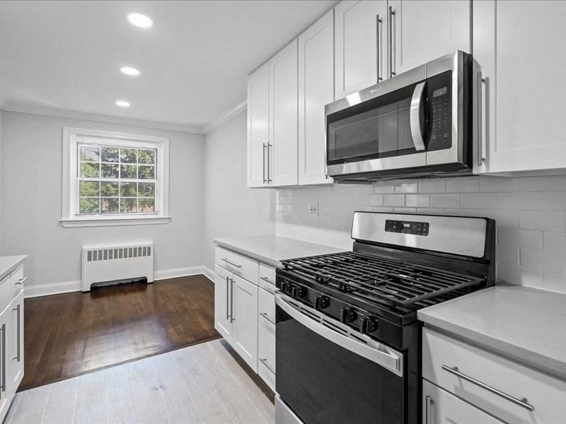 a white kitchen with a stove and a microwave