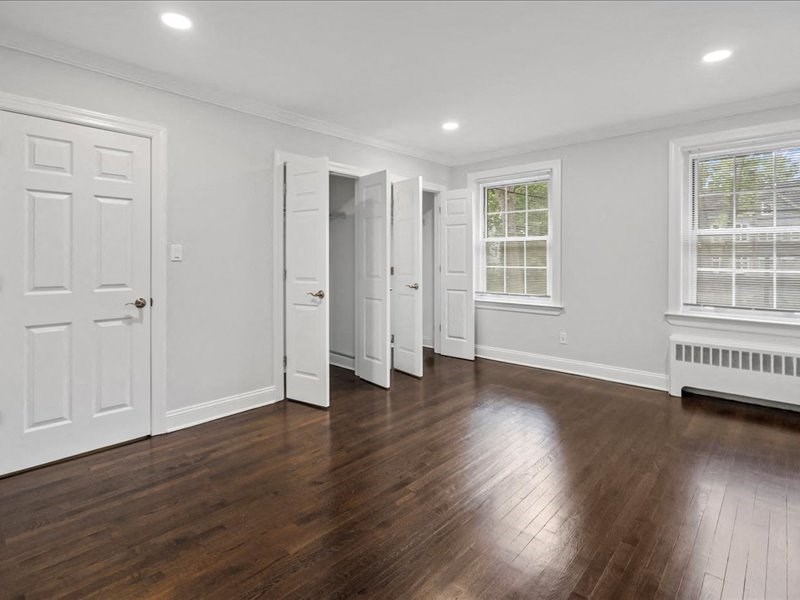an empty living room with white walls and wood floors