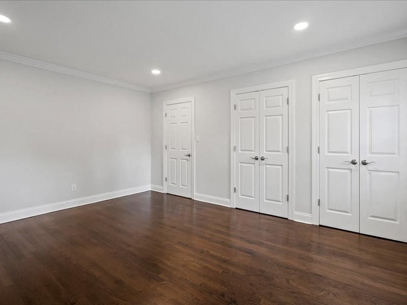 an empty living room with white walls and a wood floor