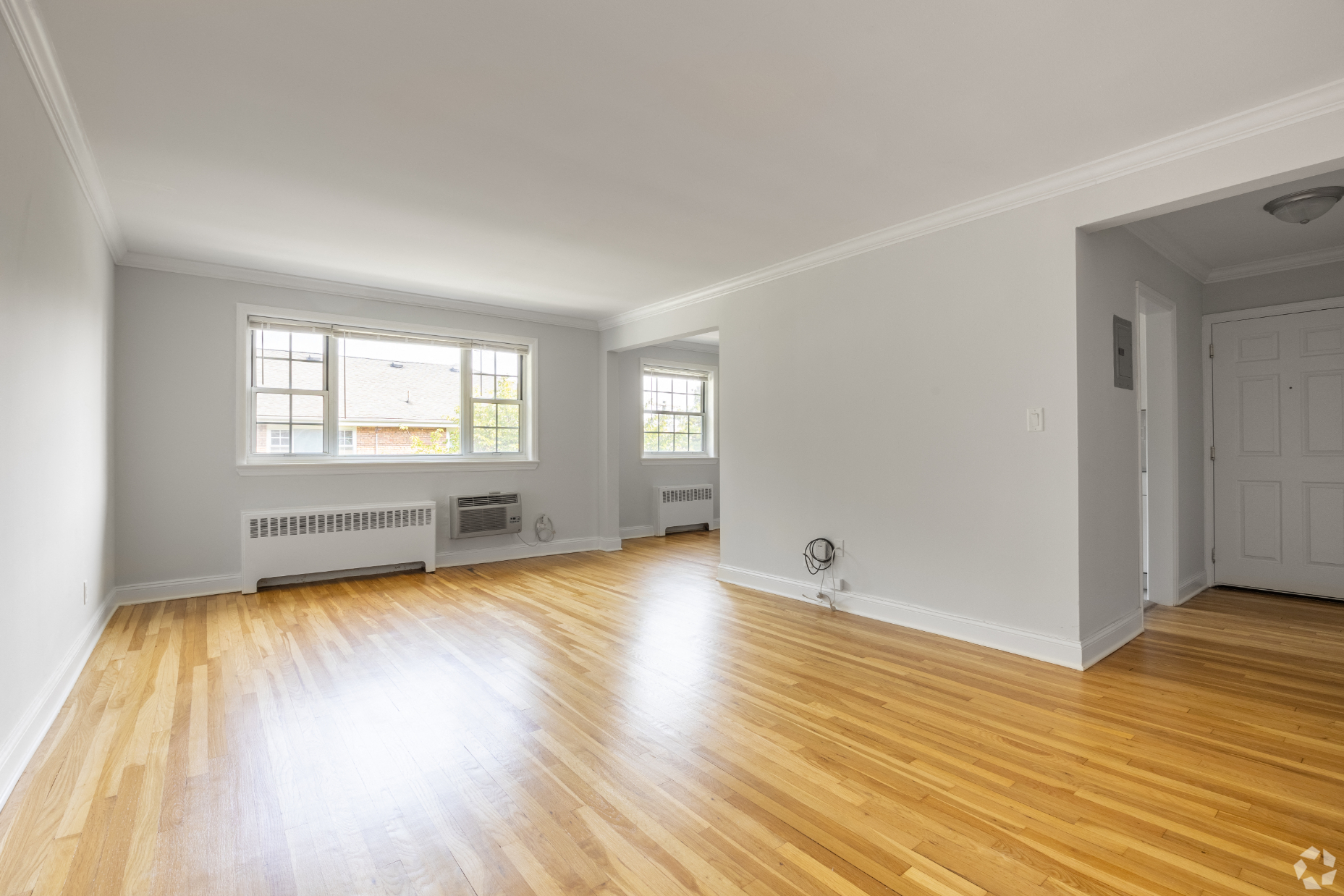an empty living room with white walls and wood floors
