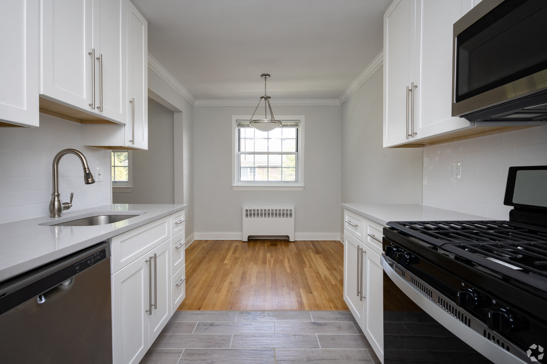 a kitchen with white cabinets and a stove and a window