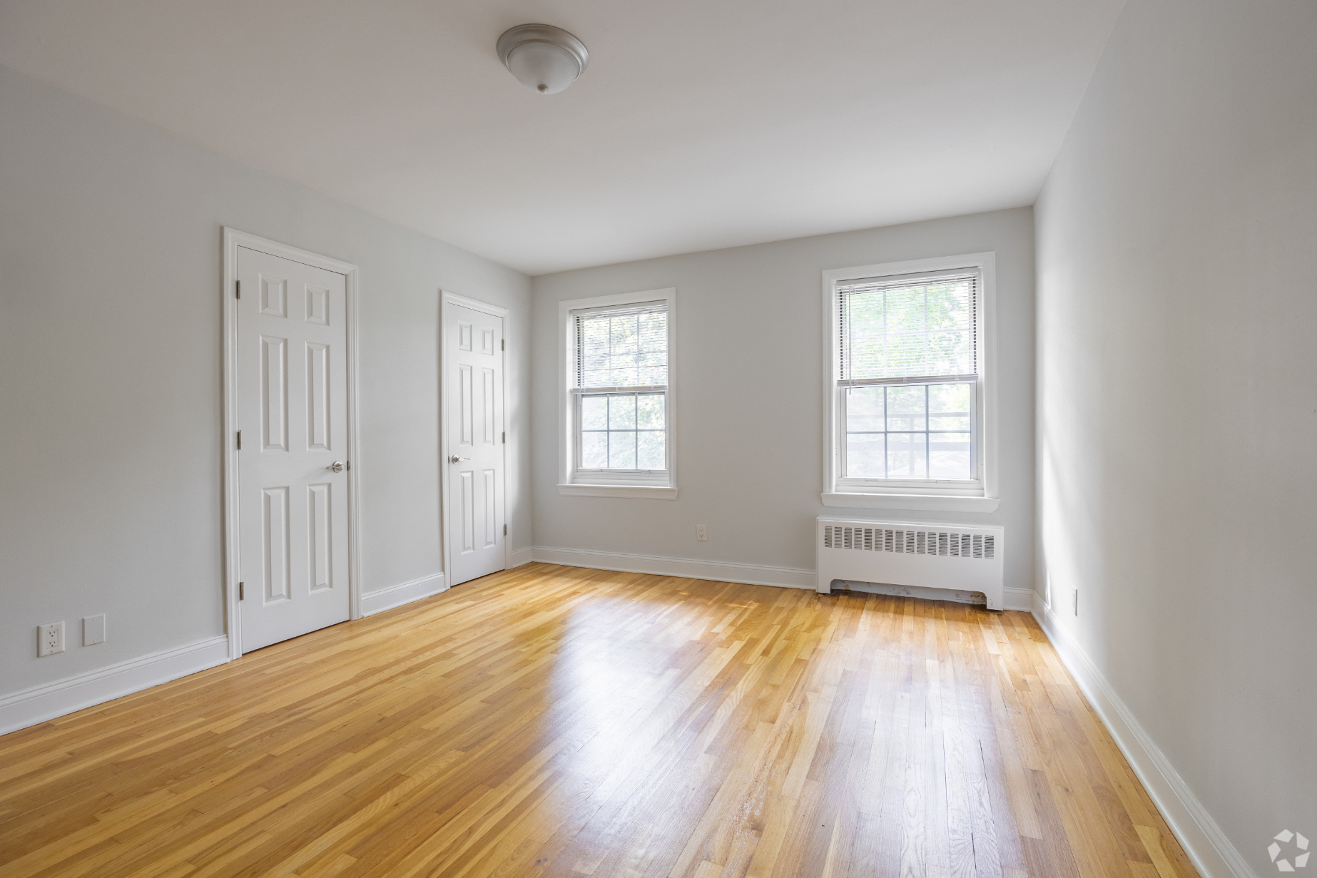 an empty living room with white walls and wood floors
