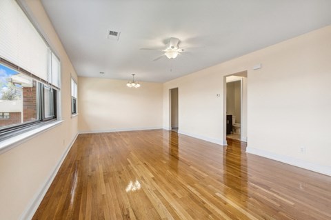 an empty living room with wood floors and a large window