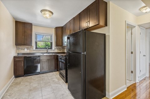 a kitchen with black appliances and wooden cabinets