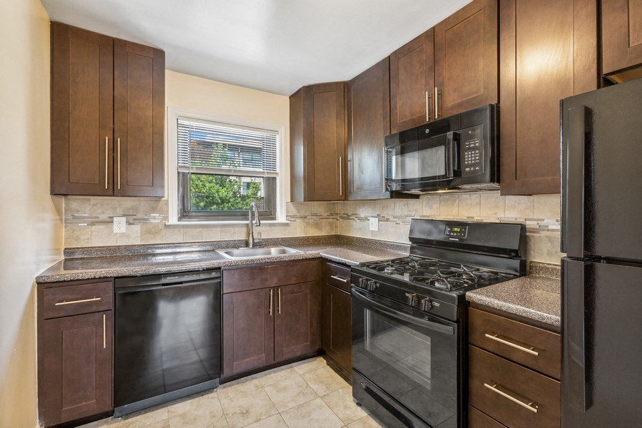 a kitchen with black appliances and wooden cabinets