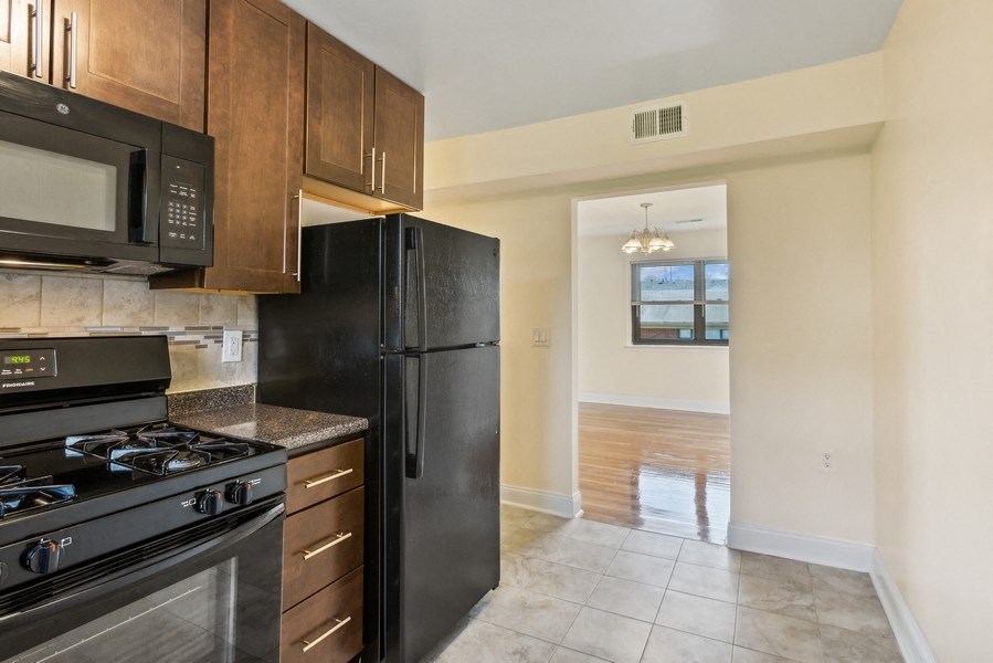 the view of a kitchen with a black refrigerator and a black stove