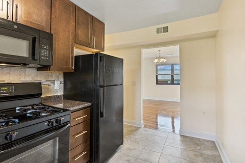 the view of a kitchen with a black refrigerator and a black stove