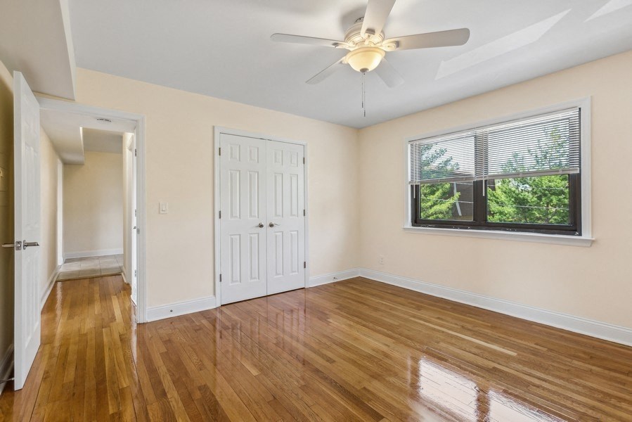 an empty living room with a ceiling fan and a window