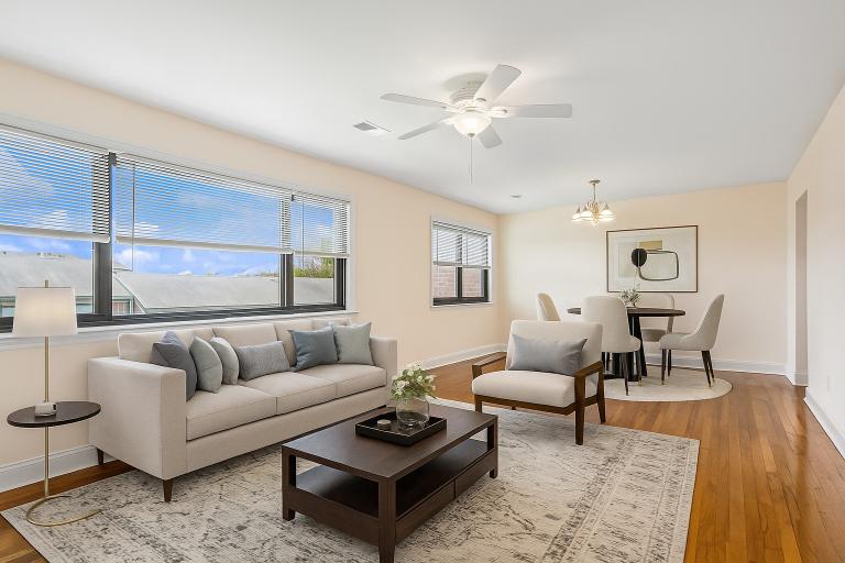 A living room with a grey couch, a coffee table, and a dining table with chairs.