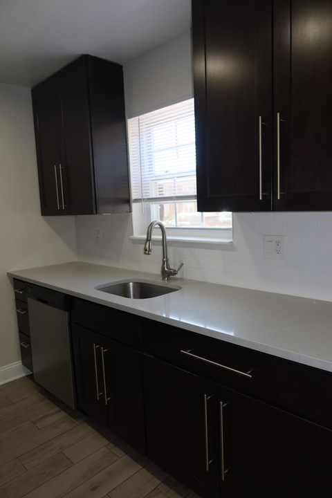 A kitchen with black cabinets and a white countertop.