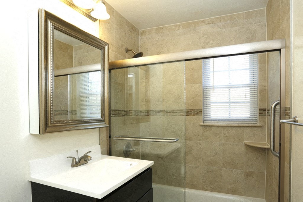 a bathroom with a shower and a sink and a mirror