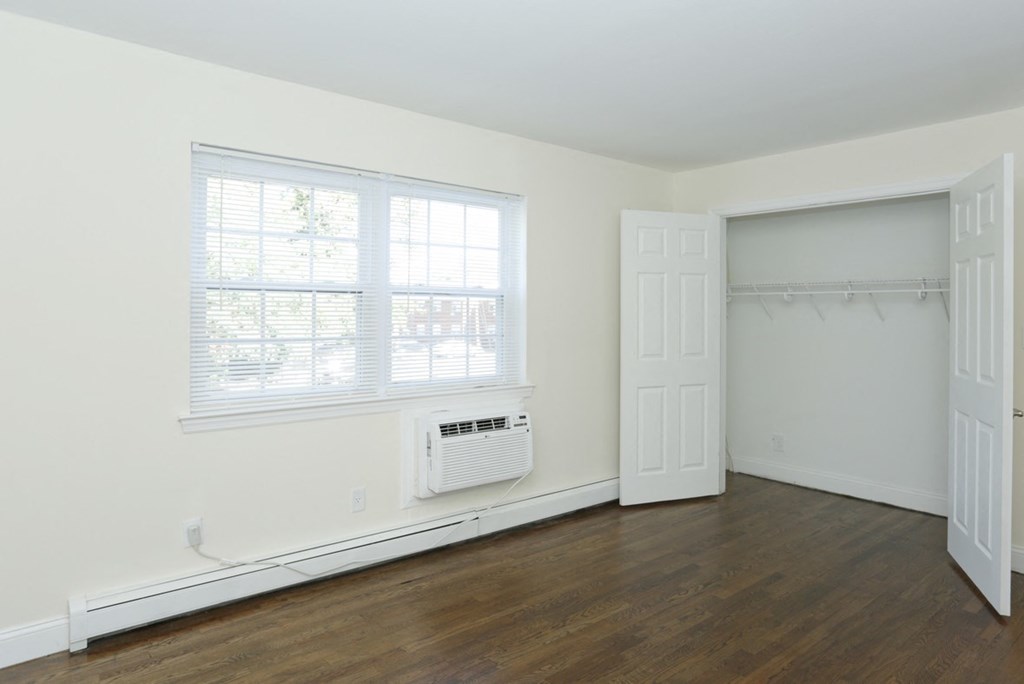 an empty room with a window and a radiator and a door