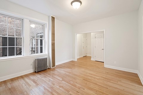 a living room with hardwood floors and a large window