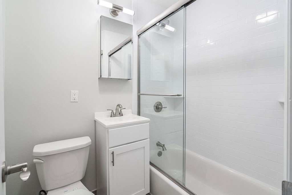 a white bathroom with a shower and a toilet