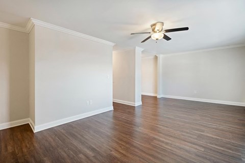 A room with a ceiling fan and wooden flooring.