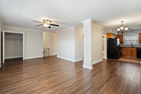 A room with a ceiling fan and wooden floors.