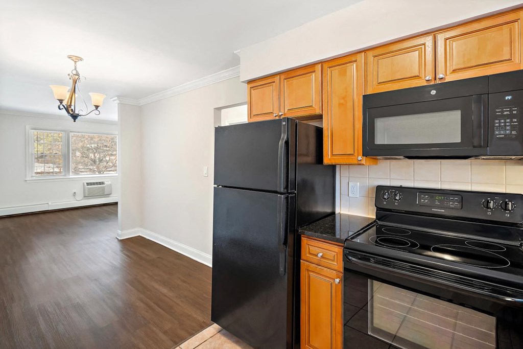 A kitchen with black appliances and wooden cabinets.