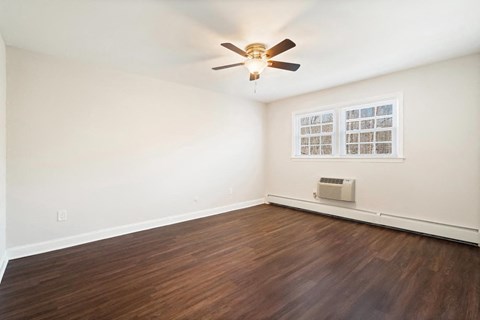 A room with a ceiling fan and a window with blinds.