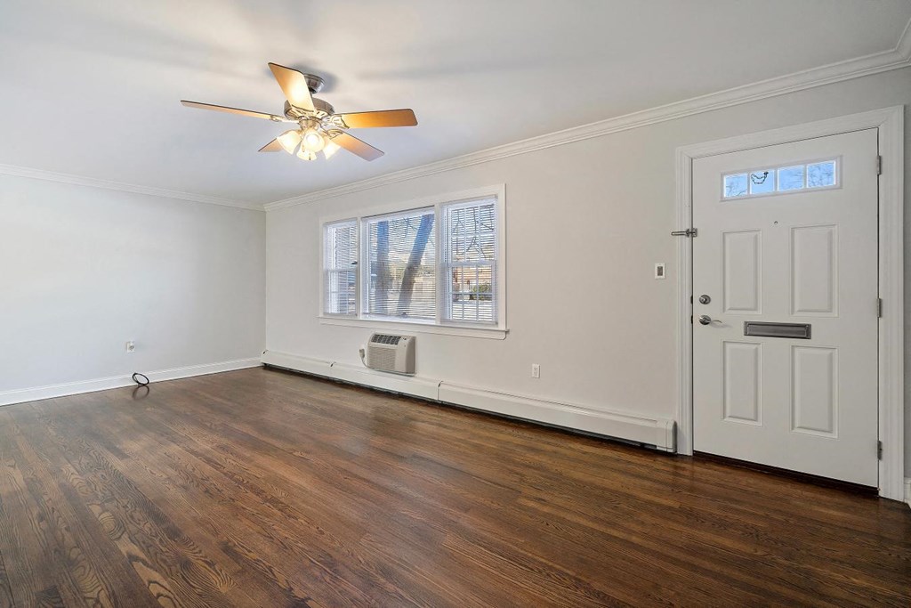 A room with a ceiling fan and a door.