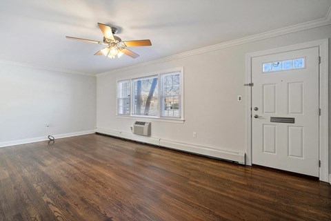 A room with a ceiling fan and a door.
