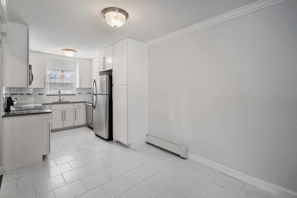 A kitchen with white cabinets and appliances.