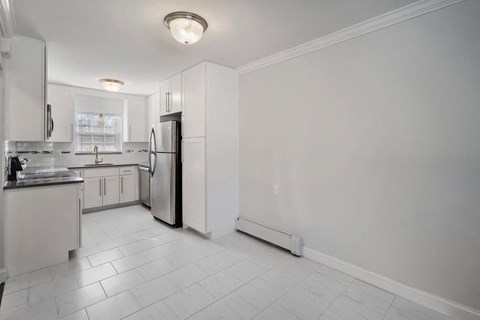 A kitchen with white cabinets and appliances.