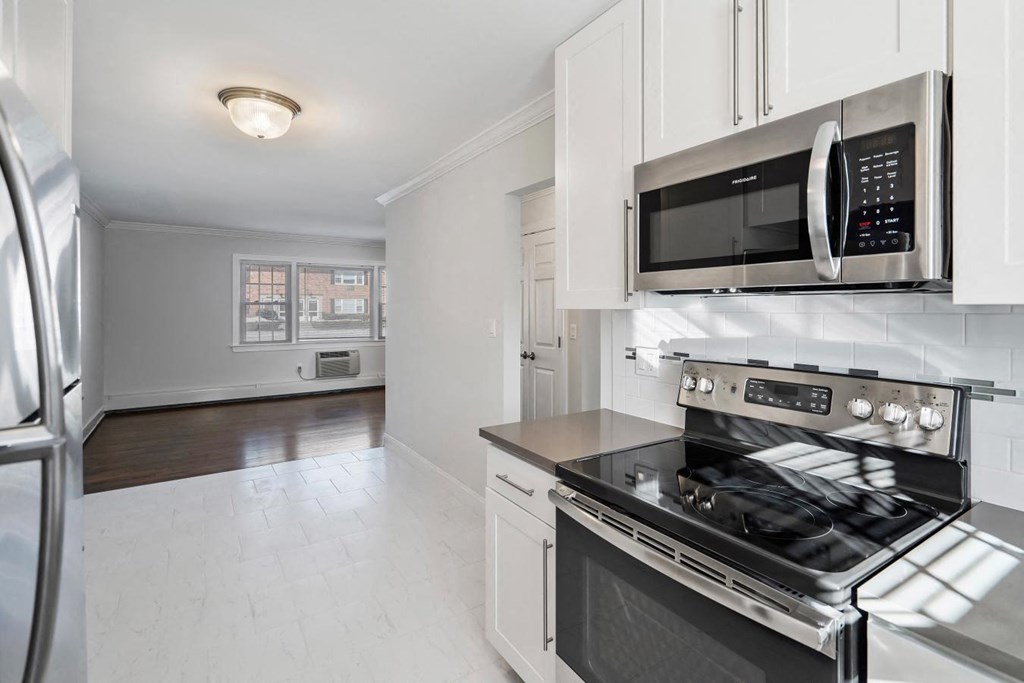A modern kitchen with a stainless steel refrigerator, microwave, and oven.